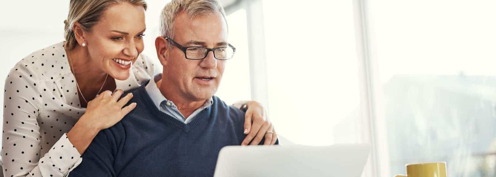 a man in a sweater looking at a laptop